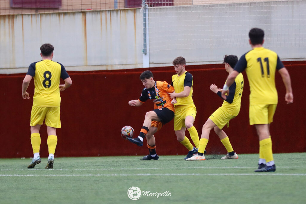 Curro protege el balón ante un defensa (Foto: @mariquilla2999).